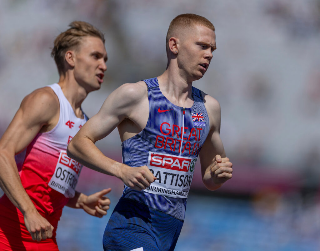 Ben Pattinson competes in the men's 800m semi-finals. He is white with short ginger hair and is wearing a blue striped race suit.